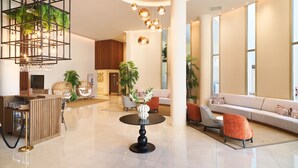 A spacious lobby with a reception desk, seating area, and large windows. - Leonardo Boutique Hotel Larnaca (Larnaca)