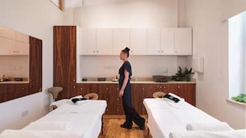 Relax in a serene space with two single beds, a sink, and a large mirror.