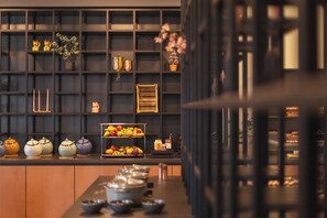 Una cocina moderna con salpicadero negro, armarios de madera y una exhibición de frutas.