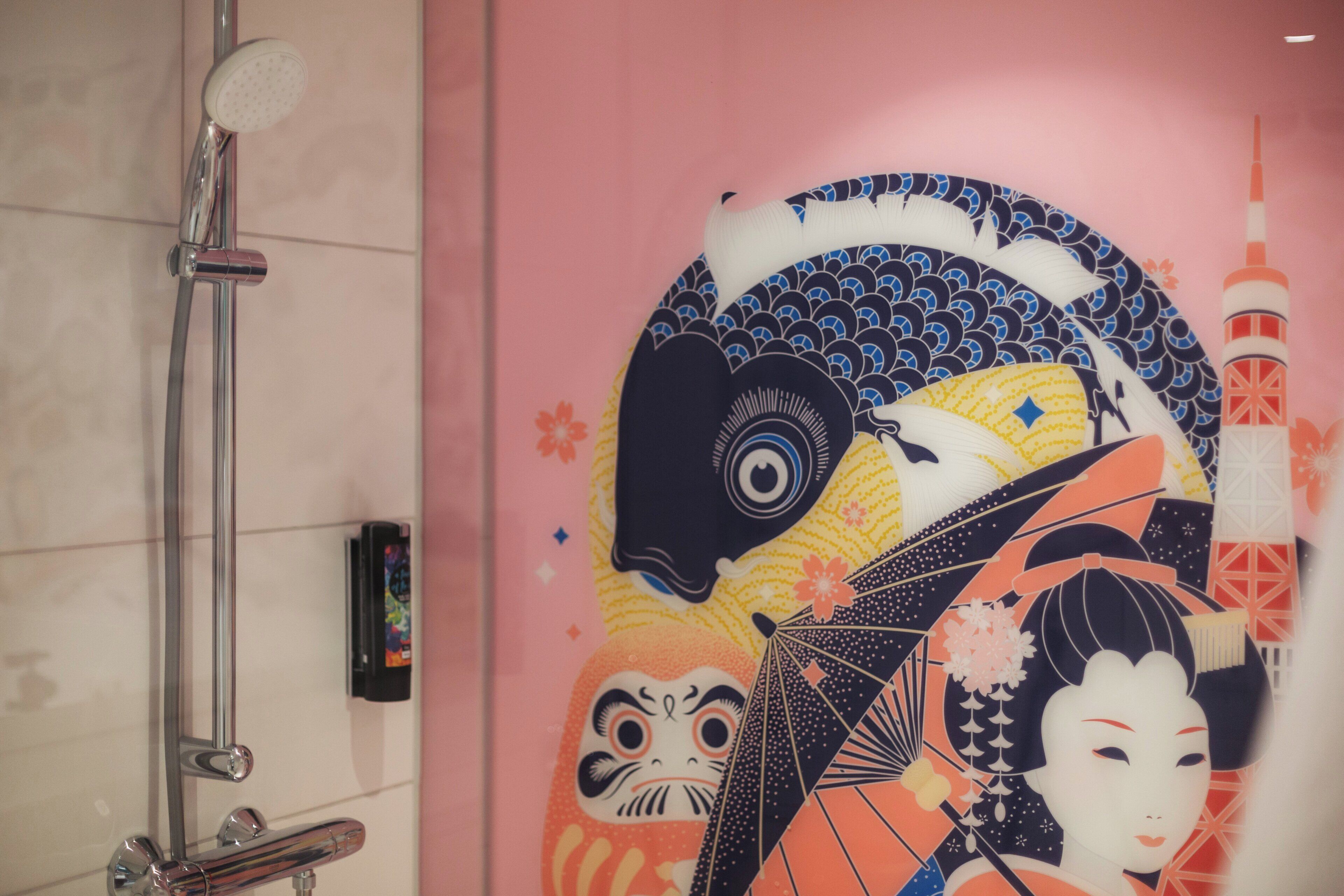 A bathroom with a traditional Japanese-style wall mural, a modern showerhead, and a visible water heater.