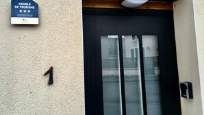 A building entrance with a sign reading "MEUBLÉ DE TOURISME" and the number "1" indicating the entrance. - Meublé de Tourisme 3 Loft Industriel à Fismes (Fismes)
