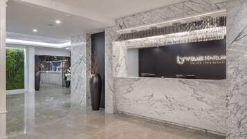 A modern reception area with marble walls and a reception desk.