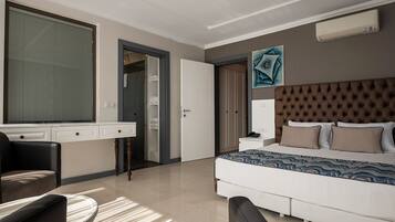 A modern bedroom with a large bed, a desk, and a chair.