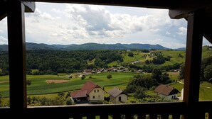 Ein malerischer Blick auf ein Dorf mit Häusern und Feldern, aufgenommen von einem Holzbalkon.