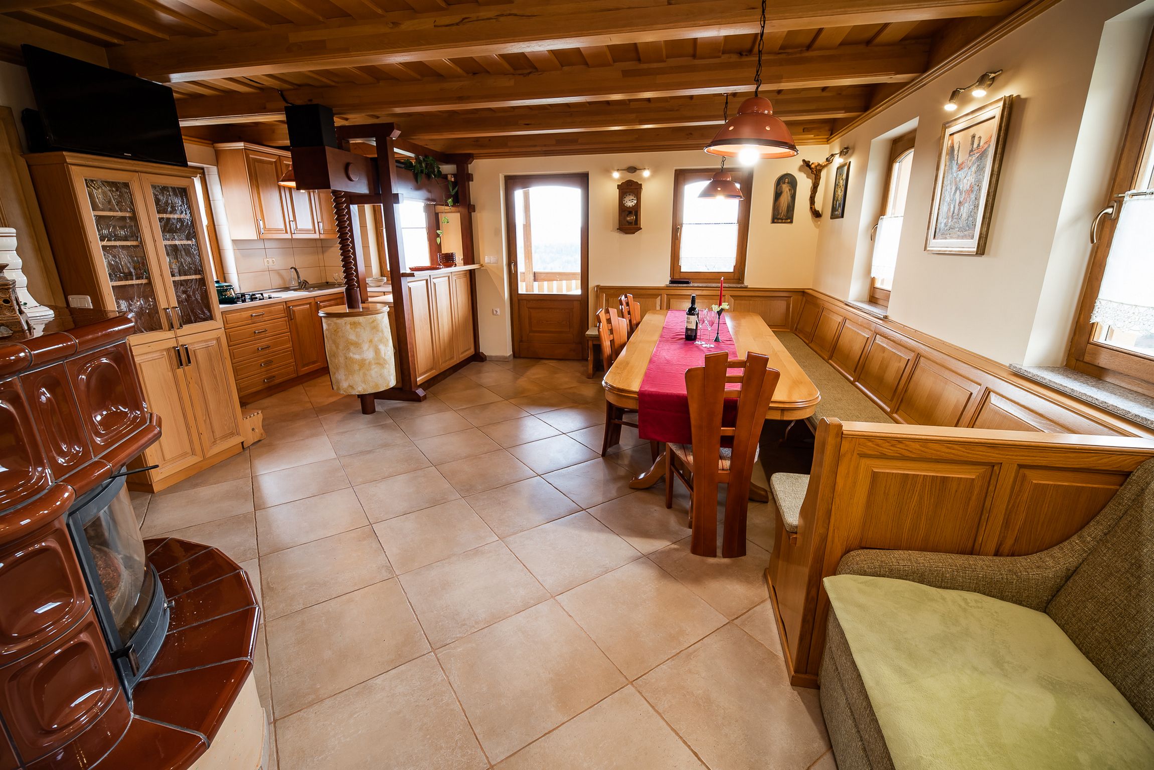 A cozy kitchen with wooden cabinets, a dining table with chairs, and a bench.