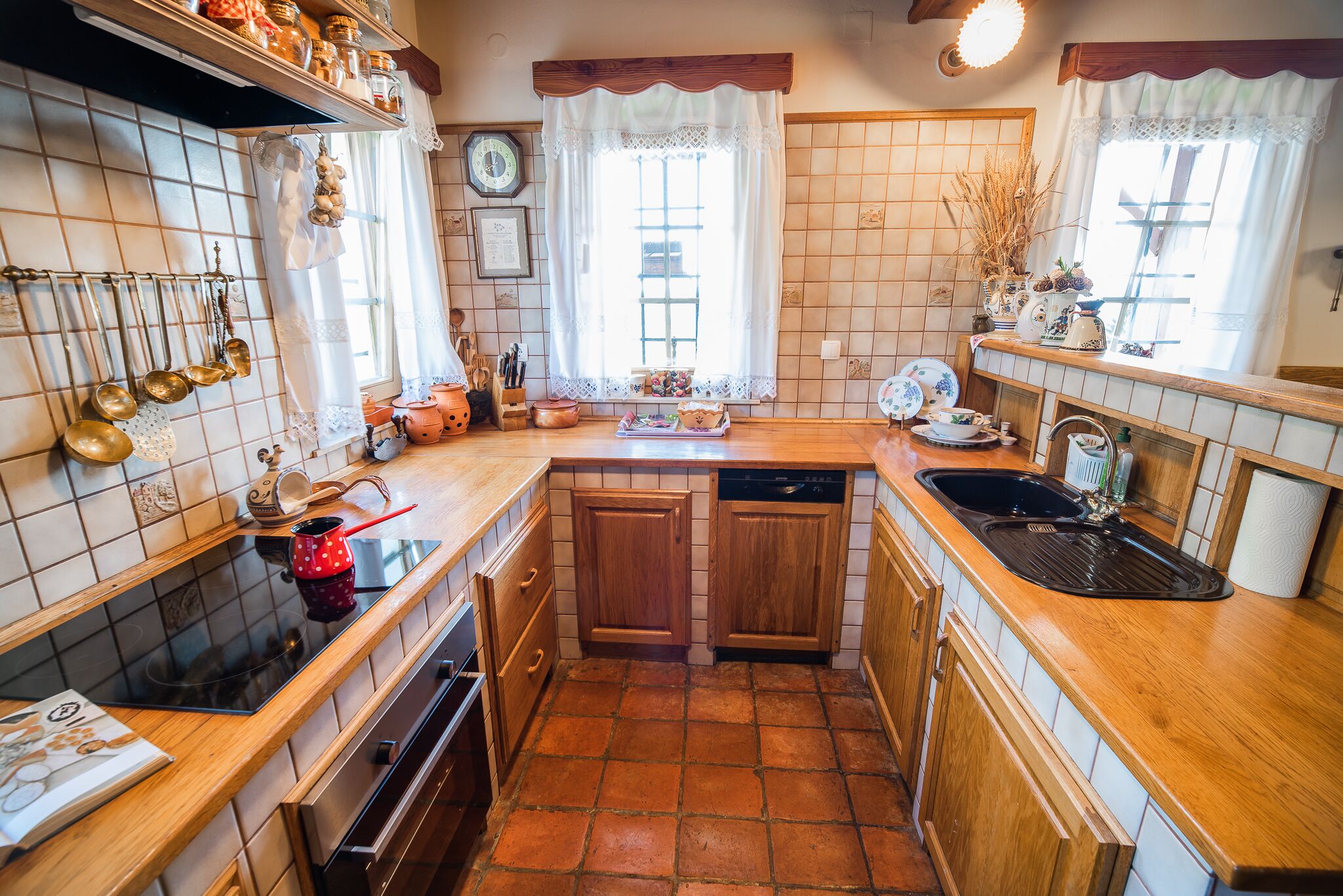 A kitchen with wooden cabinets, a black stove, and a tiled backsplash.