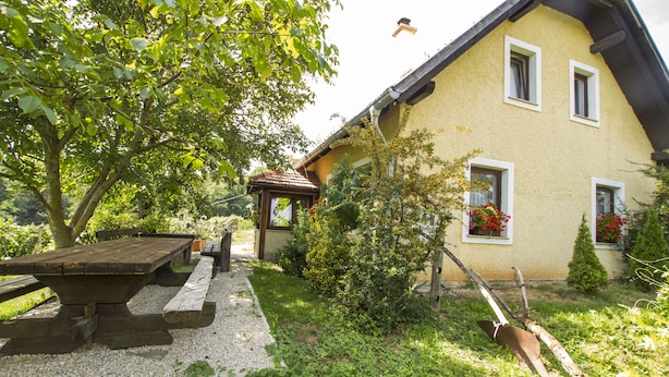 A rustic house with a wooden bench and a small garden. - Holiday Home Juricko (Brezice)