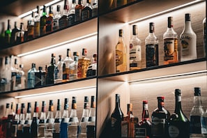 A bar with shelves of various liquor bottles. - Holiday Inn - the niu, Form Stuttgart Feuerbach by IHG (Stuttgart)