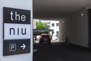 A directional sign with 'the' and 'niu' text, and a parking arrow. - Holiday Inn - the niu, Form Stuttgart Feuerbach by IHG (Stuttgart)