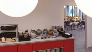 A kitchen counter with various jars and containers, a cutting board with a knife, and a basket of bread.
