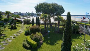 Un jardín bien cuidado con diversas plantas y una vista despejada de la playa al fondo.
