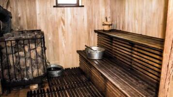 Eine kleine Küche mit Holzwänden, einem kleinen Fenster und einem Metallherd.