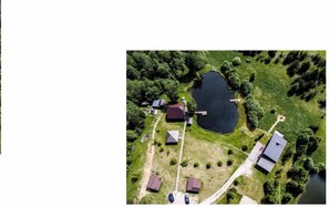 An aerial view of a property with a large pond, several buildings, and a dock. - Private Sauna Villa "Berneliu Kaimas" (Miciūnai)