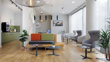 Ein modernes Interieur mit einer Sitzecke, einer Küche und einem großen Fenster.