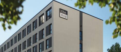 A modern building with a sign reading "the niu" on its facade.