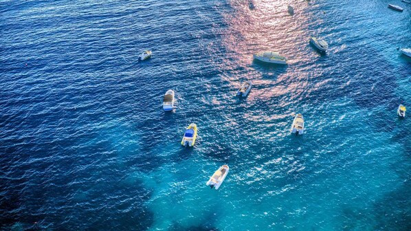 An aerial view of a marina with several boats docked and a few in the water.