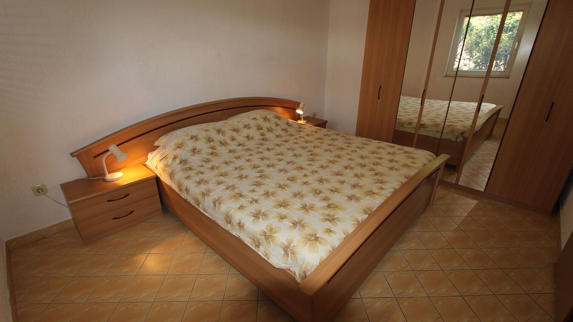 Ein Schlafzimmer mit einem Bett, einem Nachttisch und einem Spiegel.