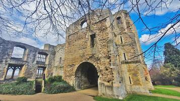 A historic stone building with arched doorways and a large central archway.
