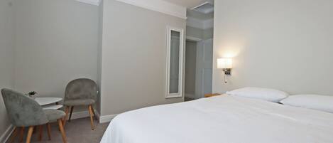 Ein Hotelzimmer mit einem Bett, zwei Stühlen, einem kleinen Tisch und einer Lampe.
