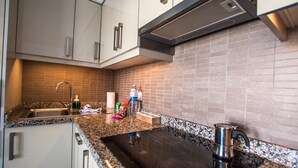 A modern kitchen with granite countertops, stainless steel appliances, and a tiled backsplash. - Casa Anemona with terrace, shared pool, sea views and free wifi (Puerto del Carmen)