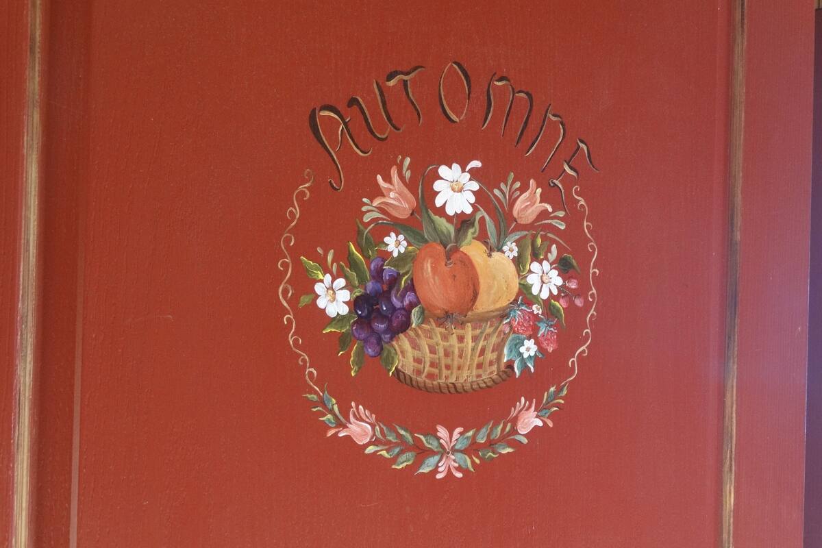 Ein rotes Buchcover mit dem Titel "NATURAL" und einer Illustration von Obst und Blumen in einem Korb.