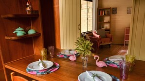 A dining table set with plates, cutlery, and a vase with a plant. - Naturaleza, Playas, Trecking, Mata Atlantica, Familia y Mascotas Pequeñas Bienve (vila abraoo)