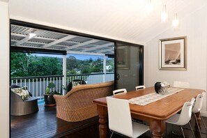 Enjoy meals in this dining area with a table for six, surrounded by a grid-patterned ceiling and a framed picture.