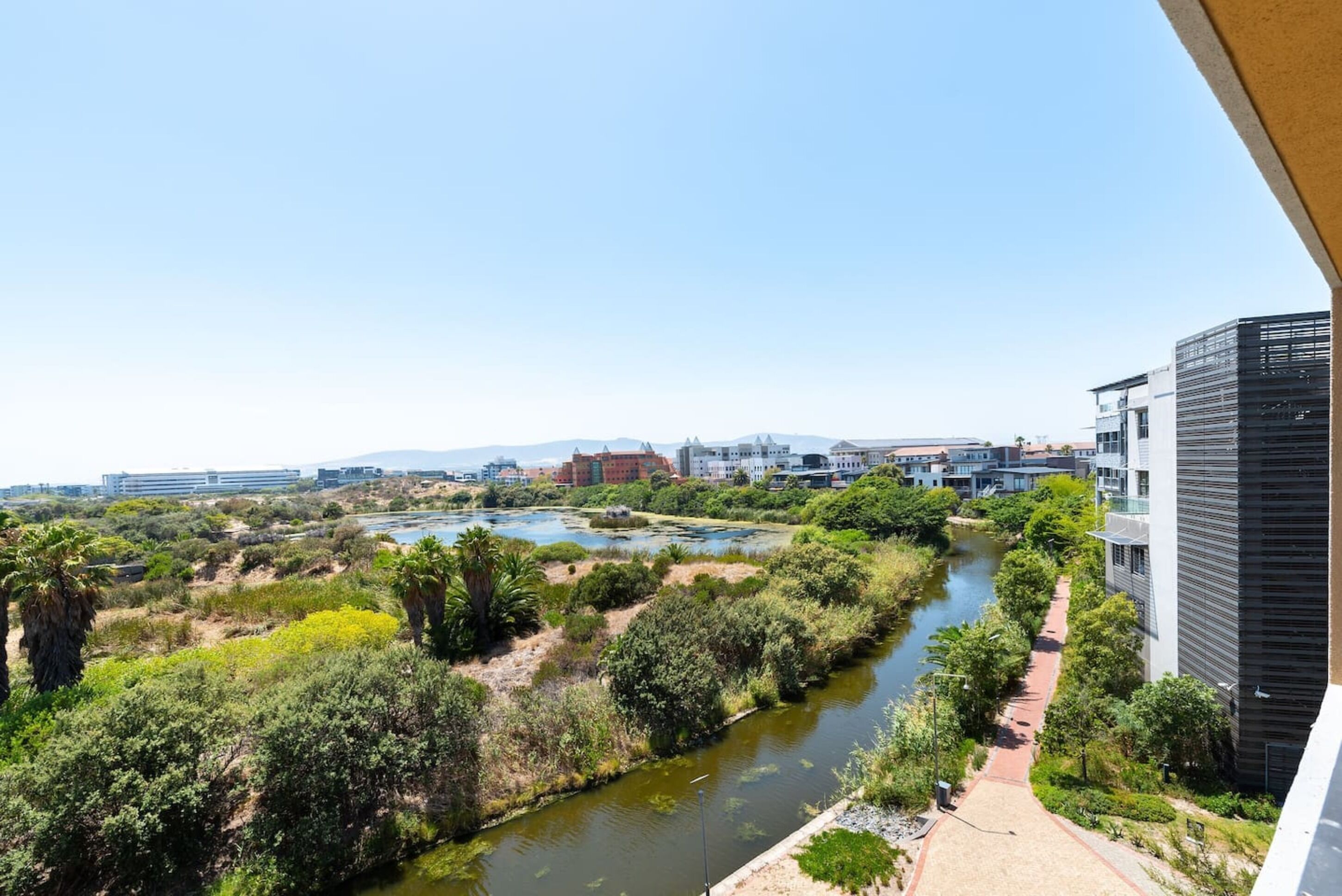 A river with greenery and buildings in the background.