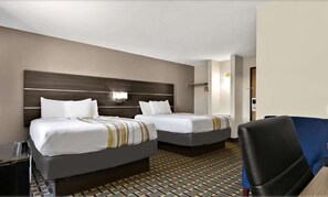A hotel room with two beds, a desk, a chair, and a patterned floor. - Surestay Plus Hotel by Best Western Tulsa East (Tulsa)
