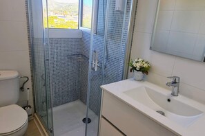 Regadera, secadora de cabello, toallas, papel de baño 