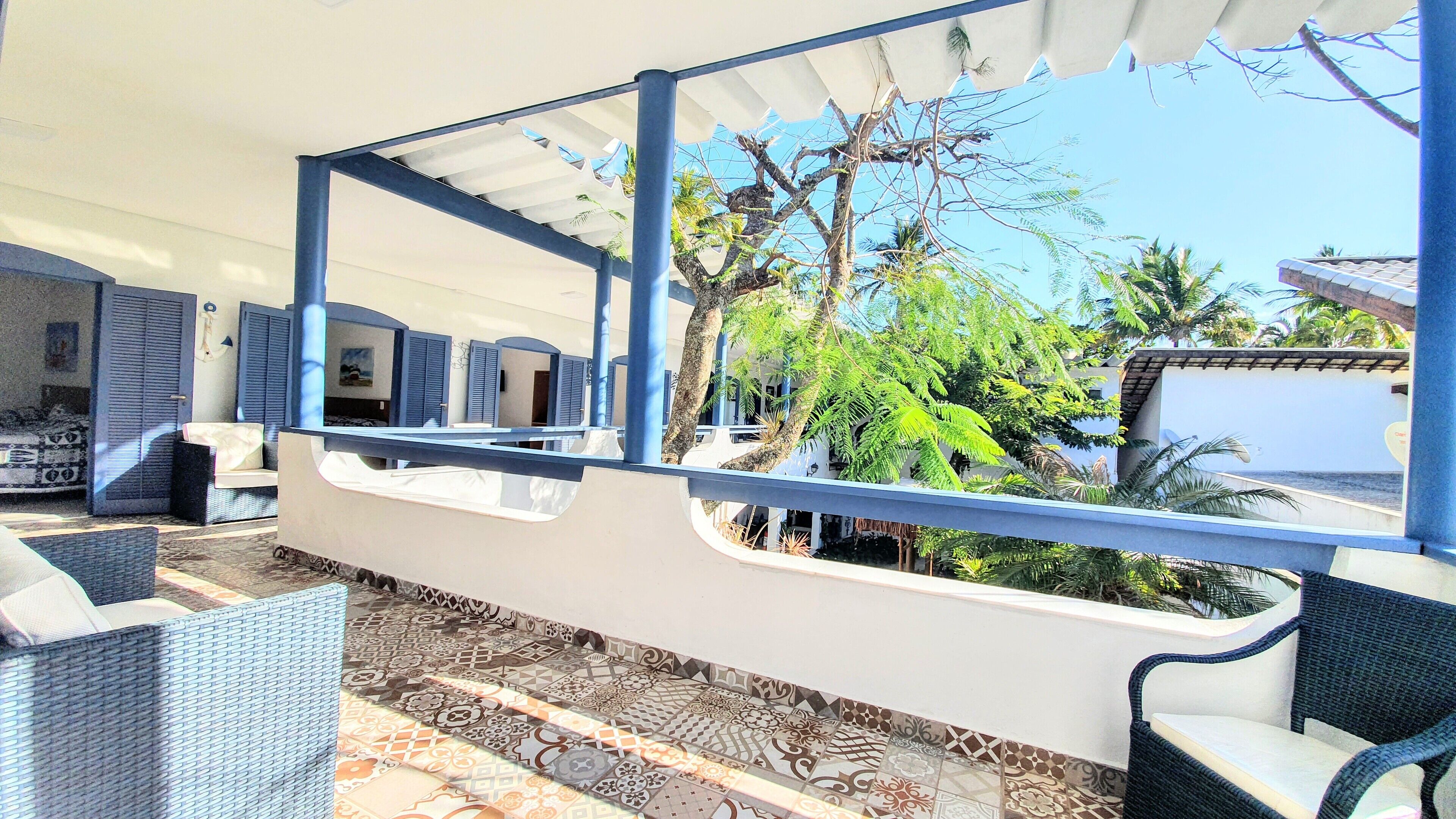 A room with a patterned floor, a white ceiling, and a view of the outdoors including trees and a building.