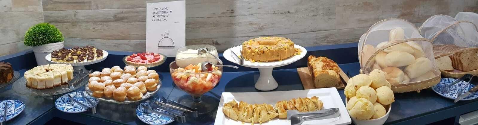 Un bufé con diversos postres y pasteles, incluyendo tortas, tartas y ensaladas de frutas.