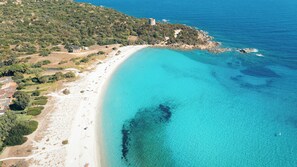 An aerial view of a coastal area with a beach, a tower, and surrounding greenery. - Campagna e Mare a Pochi Minuti da Costa Rei (Castiadas)