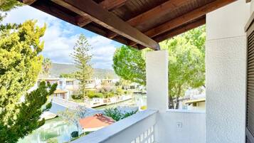 Enjoy a serene garden and canal view from this 1st-floor bedroom's balcony.