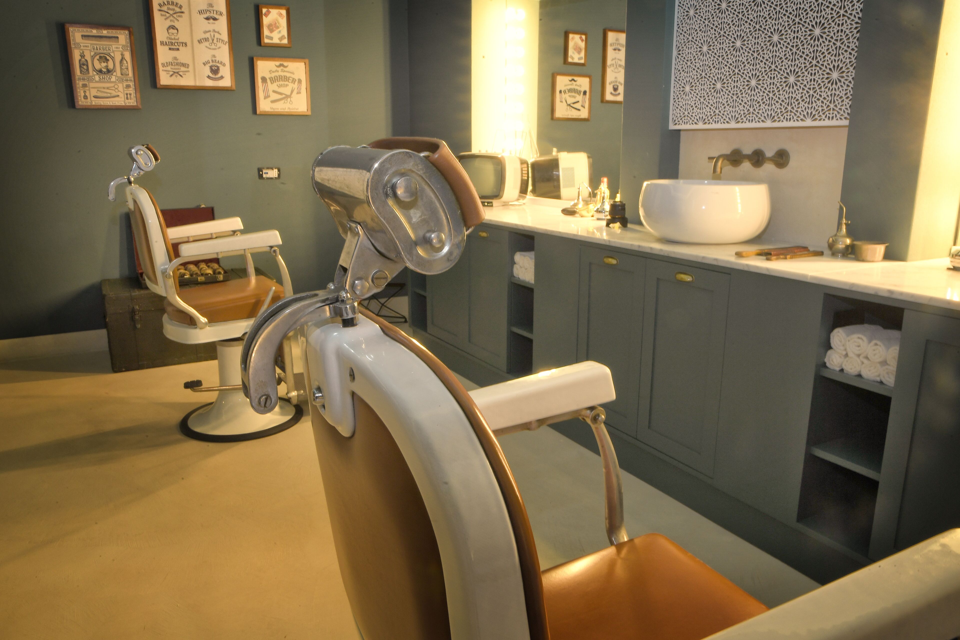 A vintage barber's chair with a mirror, a sink, and a mirror above it.