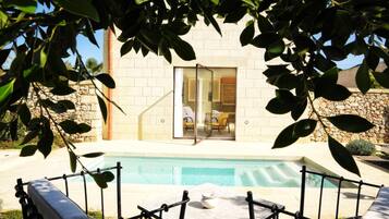 Un edificio moderno con ingresso in vetro, una piscina e area relax all'aperto.