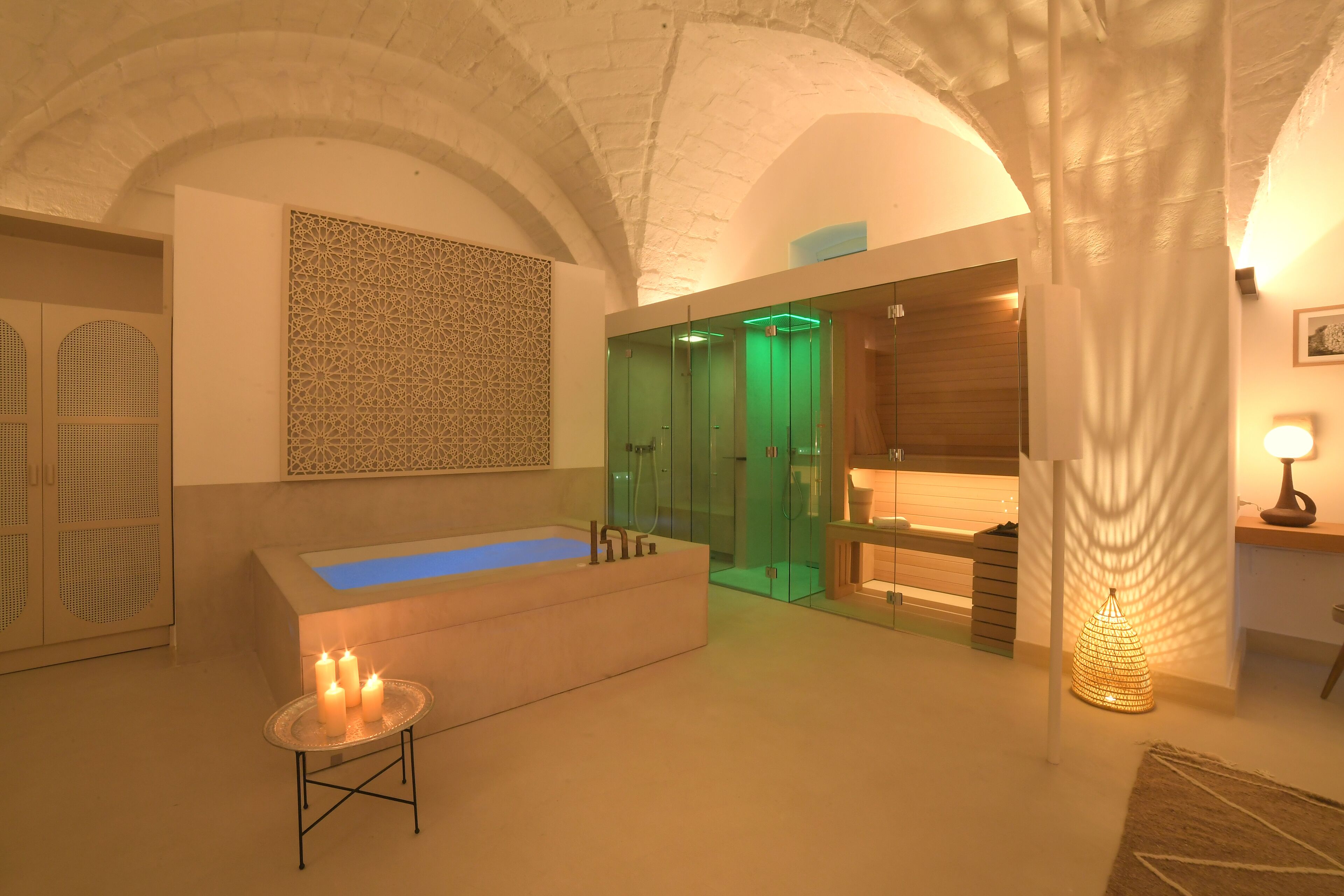 Un baño moderno con una bañera independiente, una ducha con cerramiento de cristal y un panel decorativo en la pared.