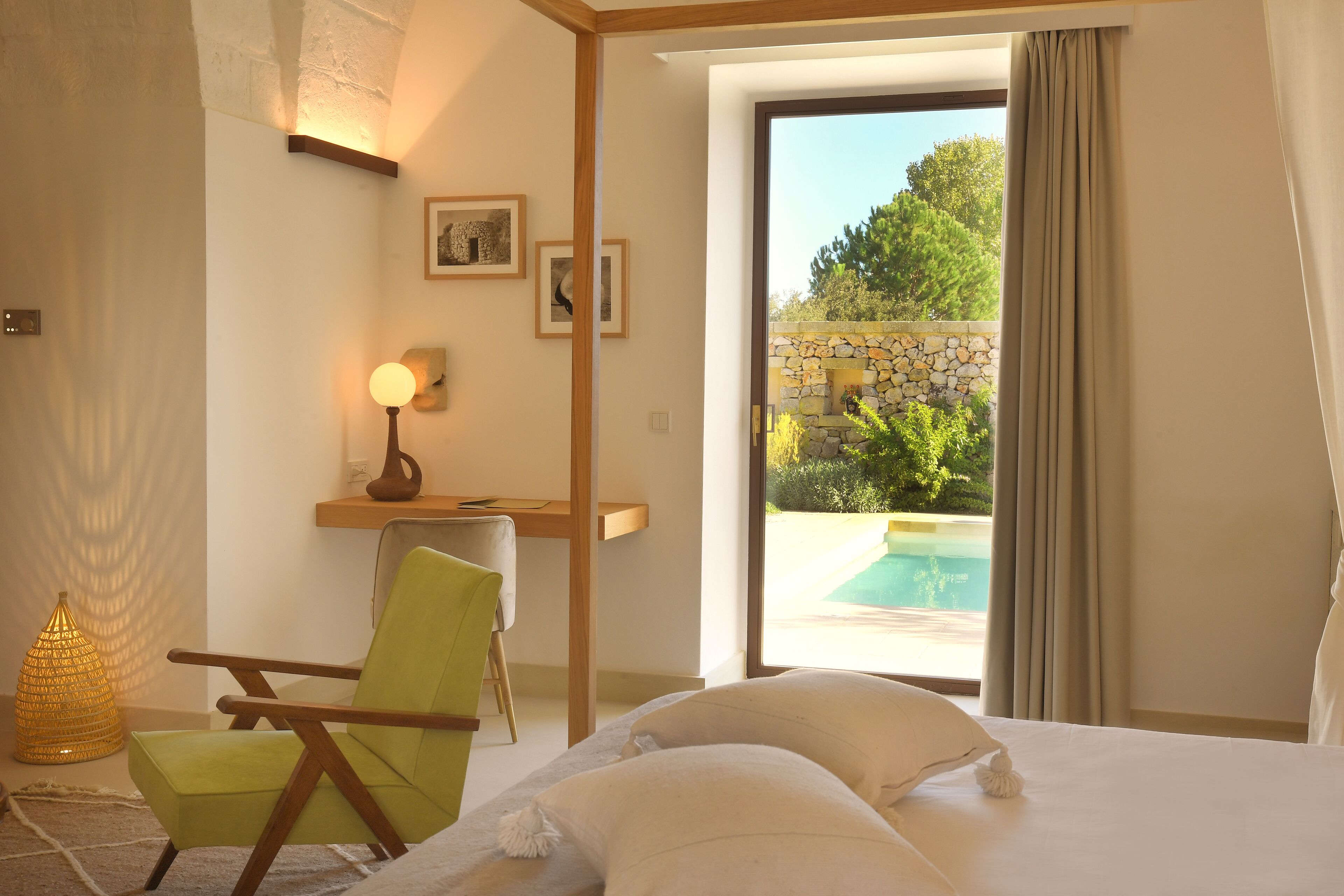 Ein Hotelzimmer mit Bett, Schreibtisch, Stuhl und Blick auf einen Swimmingpool.