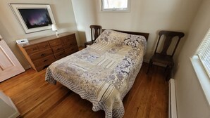 Un dormitorio con una cama grande, cómoda de madera y una mesita de noche.