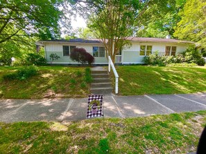 A two-story house with a front porch, a welcome mat, and a mailbox.