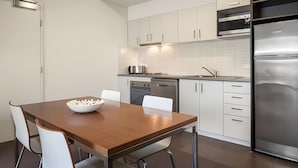 Eine moderne Küche mit weißen Schränken, Edelstahlgeräten und einem Holzespeisetisch.