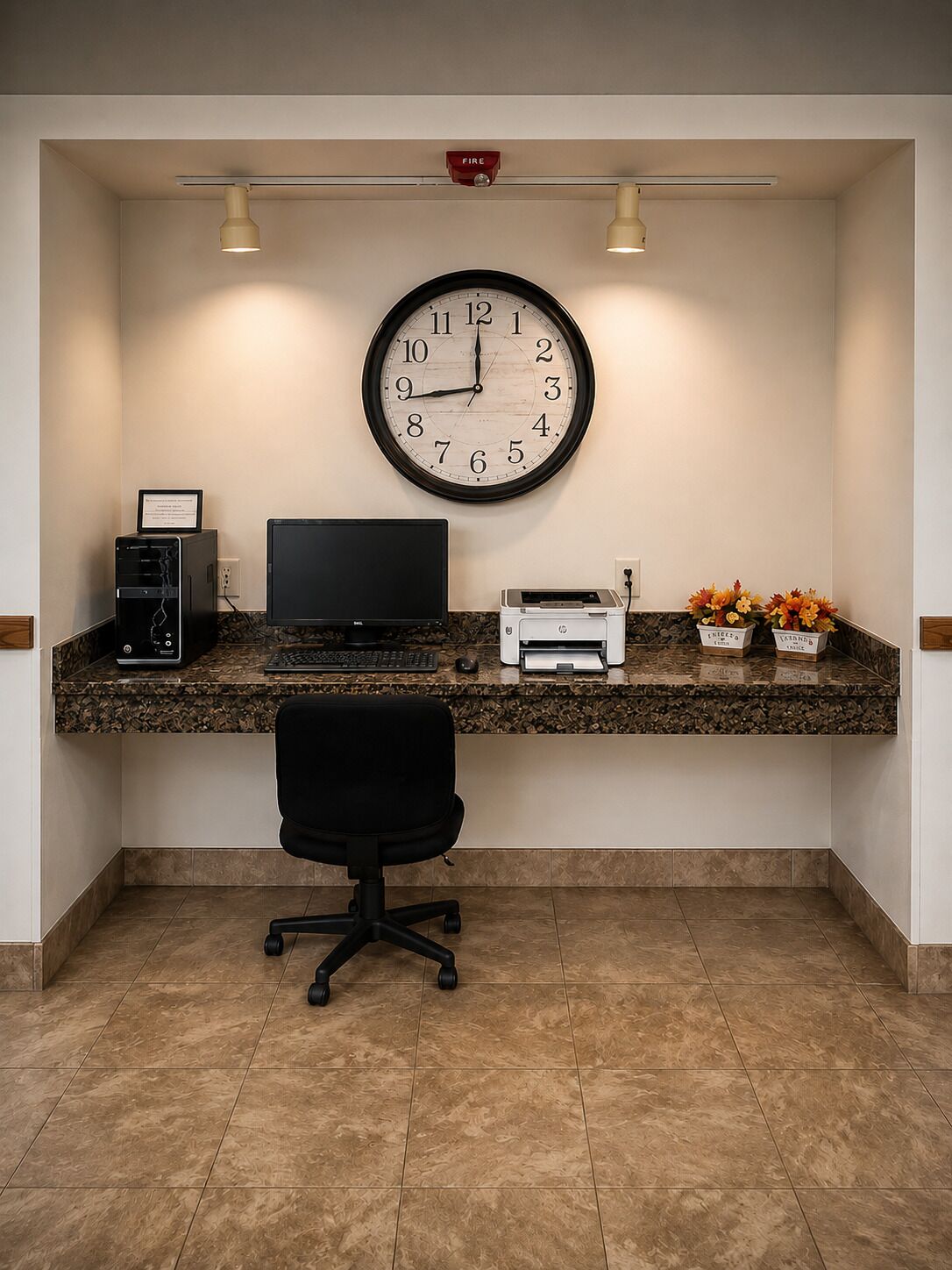 Een receptiebalie met een klok, computer, printer en een bureaustoel.