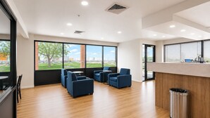 A modern office space with a reception desk, seating area, and large windows. - Days Inn by Wyndham Lake Point (Tooele)