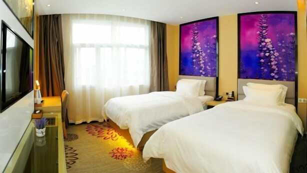 A hotel room with two beds, a TV, a desk, and a large window with curtains. - Lavande Hotels (Hangzhou Xiaoshan International Airport) (Hangzhou)