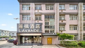 A multi-story hotel with a modern facade, featuring a prominent sign for "LAVANDE". - Lavande Hotels (Hangzhou Xiaoshan International Airport) (Hangzhou)