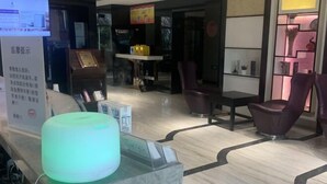 A reception area with a modern design, featuring a reception desk, seating area, and a decorative wall. - Lavande Hotels (Hangzhou Xiaoshan International Airport) (Hangzhou)