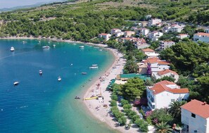 Une ville côtière avec une plage, des bateaux et des immeubles d’habitation.