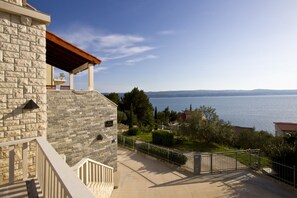 Un bâtiment en pierre doté d’un balcon donnant sur une étendue d’eau.