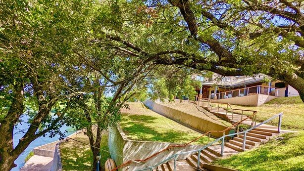 A staircase leading up to a building with a view of a body of water. - Waterfront Luxury Home on 5 Acres. 
Sleeps 22. Beds: 5 king, 4 queen, 4 twin XL (New Braunfels)