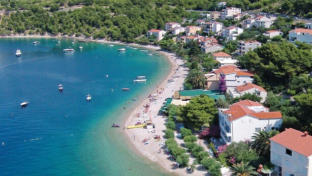 A coastal town with a beach, boats, and residential buildings.